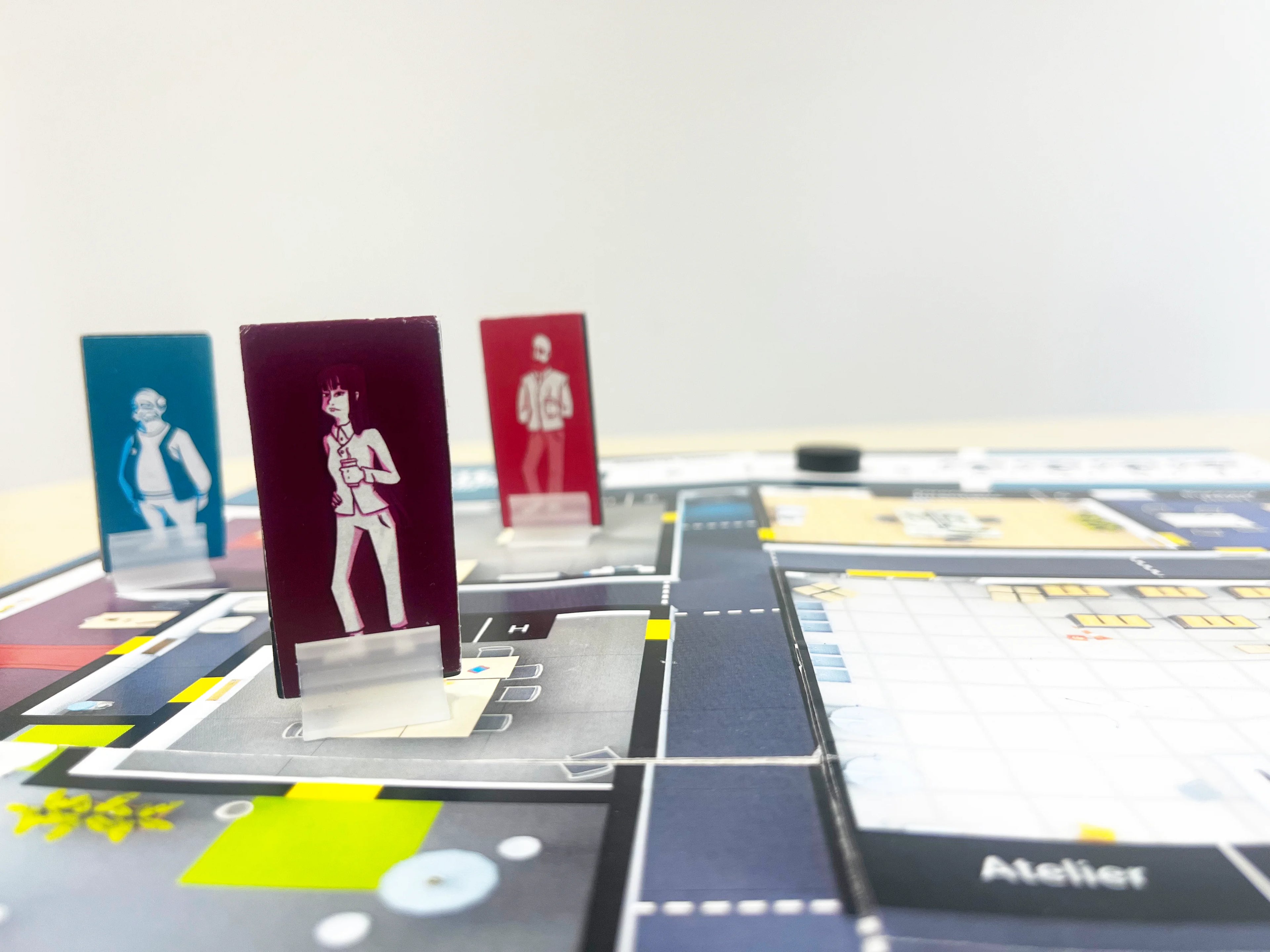 Gros plan sur les pions personnages EAHR se déplaçant sur le plateau de jeu pour mener l'enquête SST et identifier les risques professionnels.